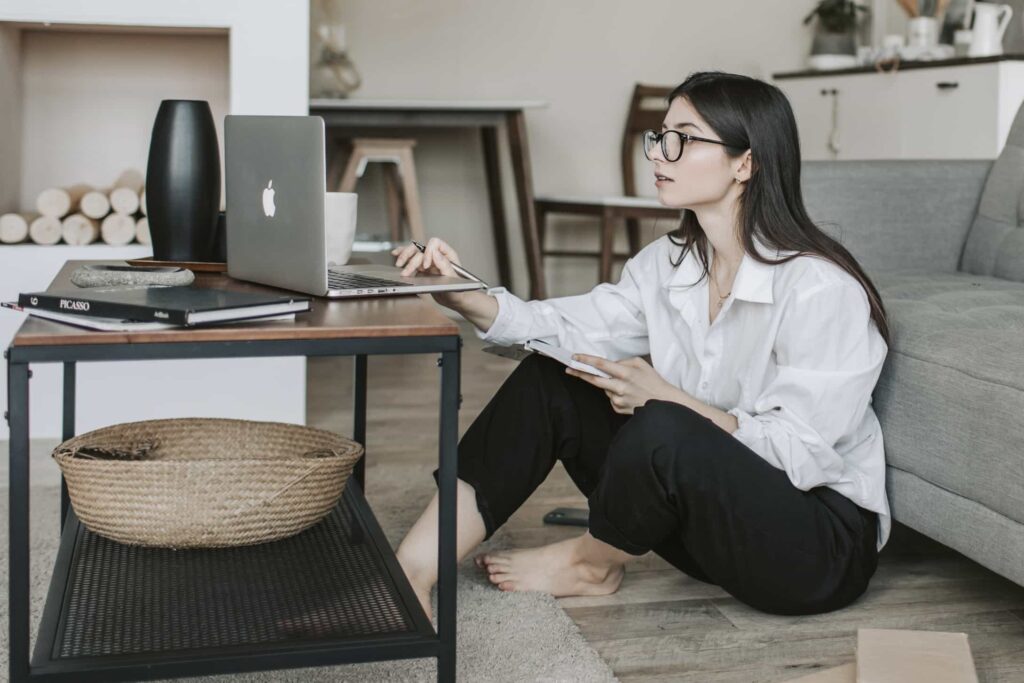 Kitchen remodel resources. Woman looking up pros and cost information on laptop