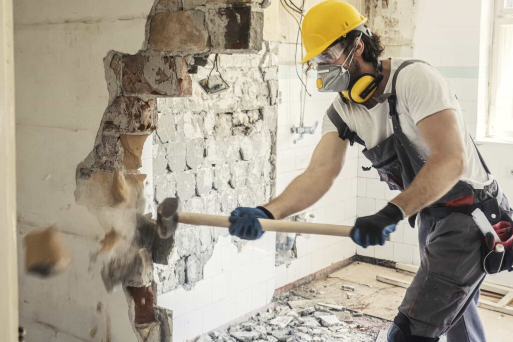 Contractor hammering through wall